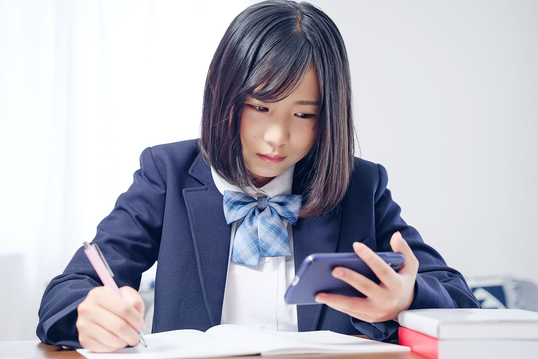 スマホを使って復習している女子学生