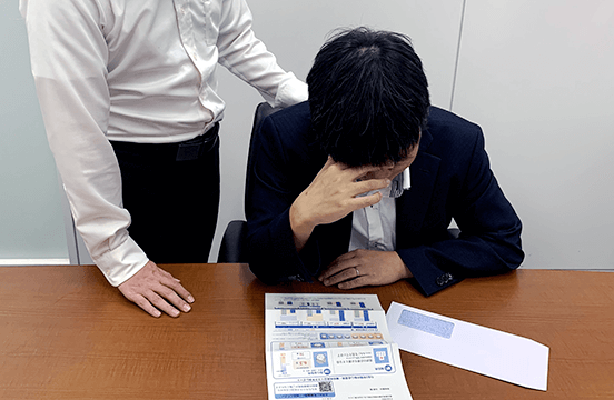 画像：発症リスク予測レポートを見て落ち込む黒瀬部長